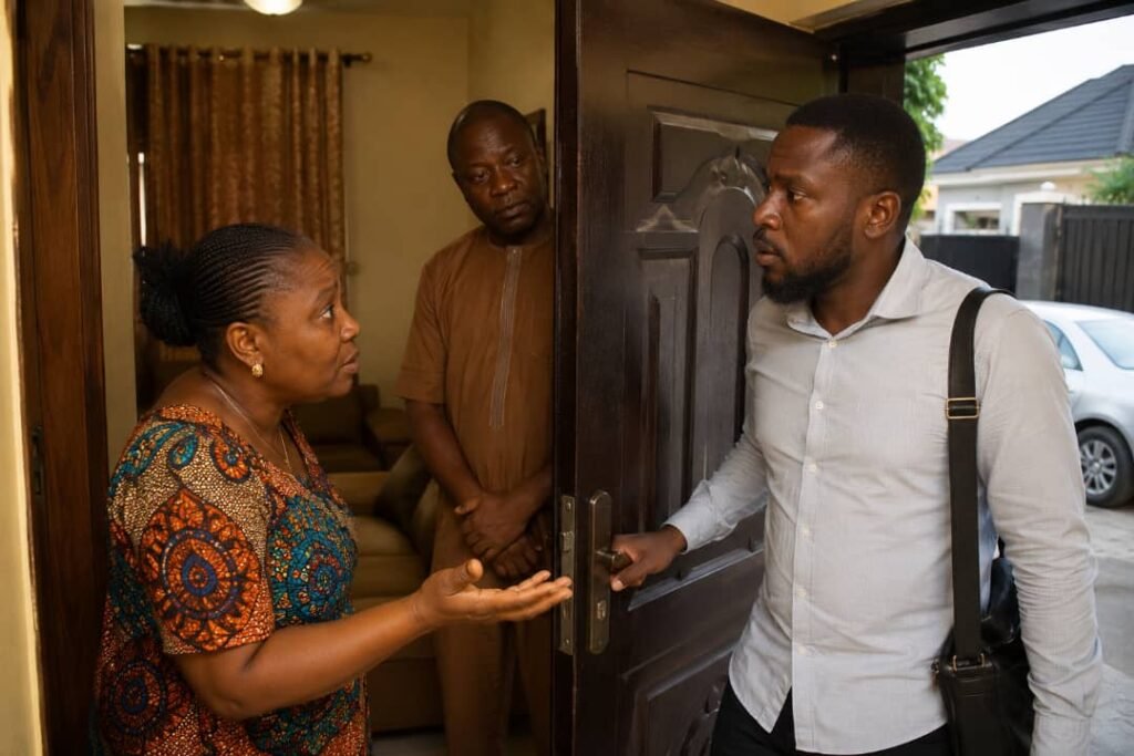 A Nigerian man pauses at the doorway during goodbye as two people inside begin a serious conversation with him.